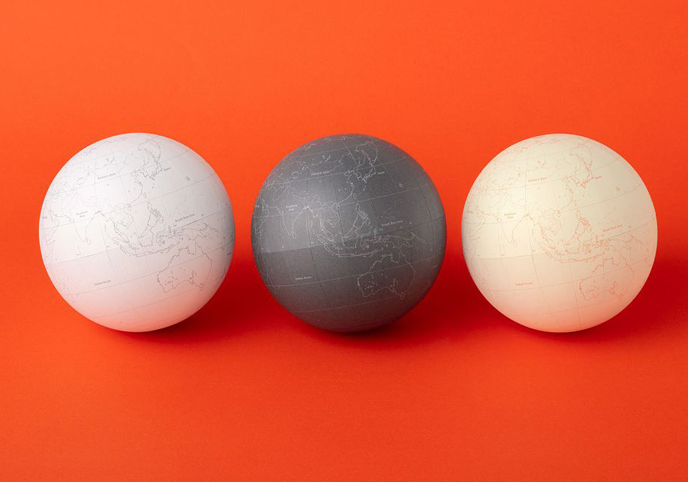 Three PLOTTER Globes in the color white, gray, and cream.