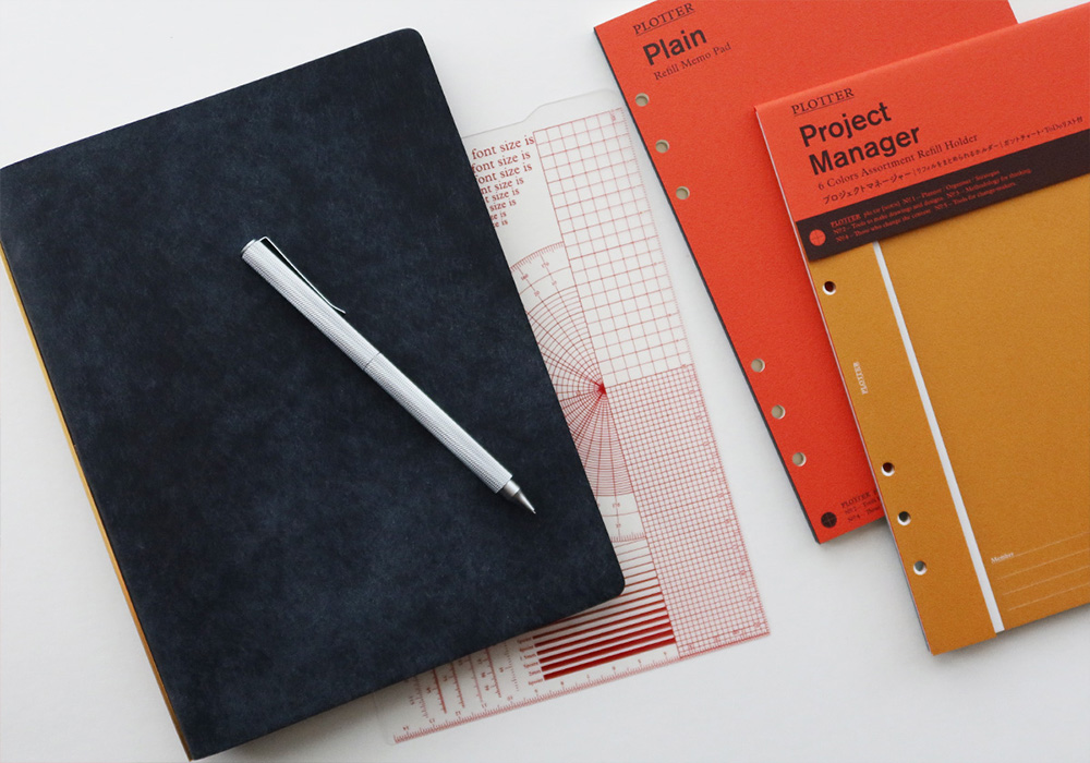 A PLOTTER Leather Binder in A5 Size beside different refill memo pads and PLOTTER refills.