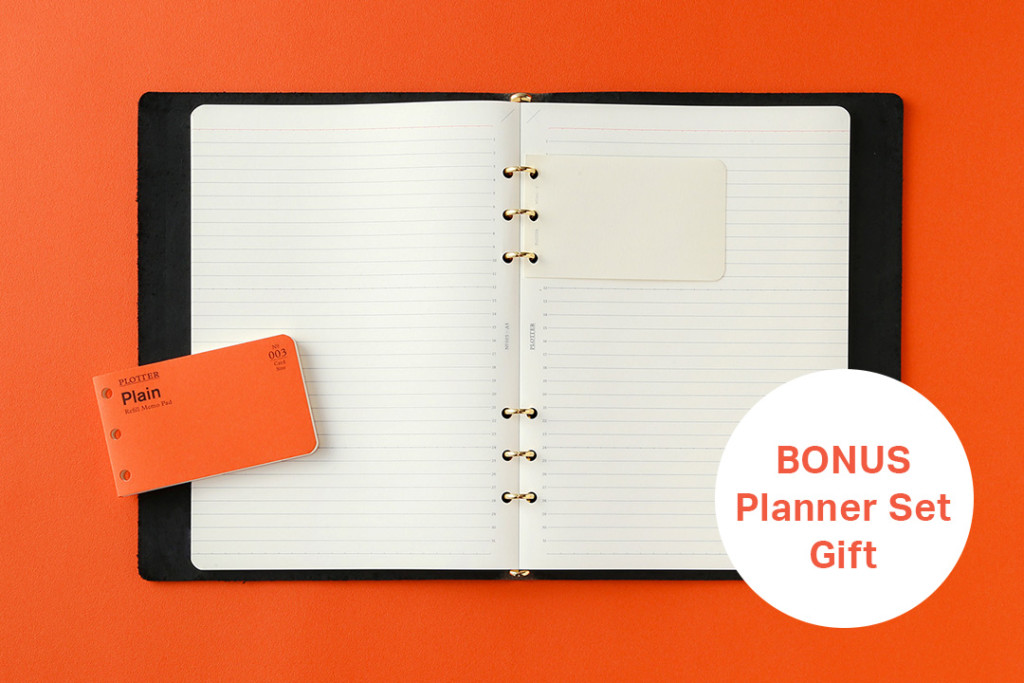 A PLOTTER Leather Binder opened to a lined page with a small memo pad on top of it.