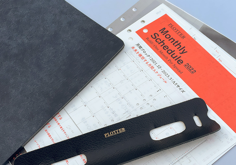 Monthly schedule refills beside a PLOTTER Leather Binder and Ring supporter.