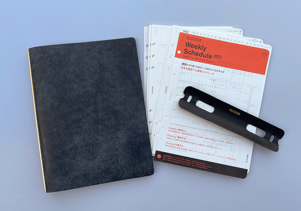 PLOTTER leather binder beside weekly calendar refills