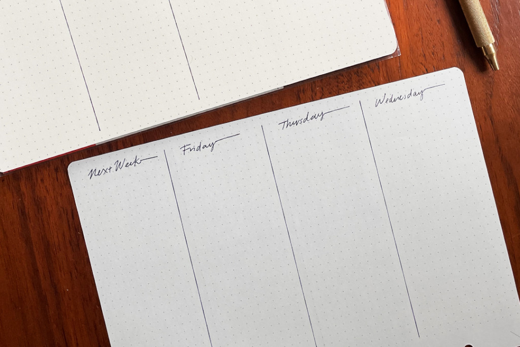 Close-up of xxample weekly schedule spread on A5 dot grid paper from PLOTTER note pad.