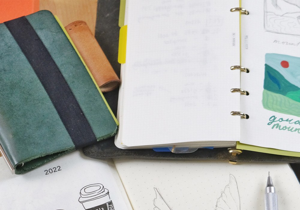 PLOTTER leather binder in Narrow Size with painting in it. PLOTTER Mini 5 Size in Green beside it.