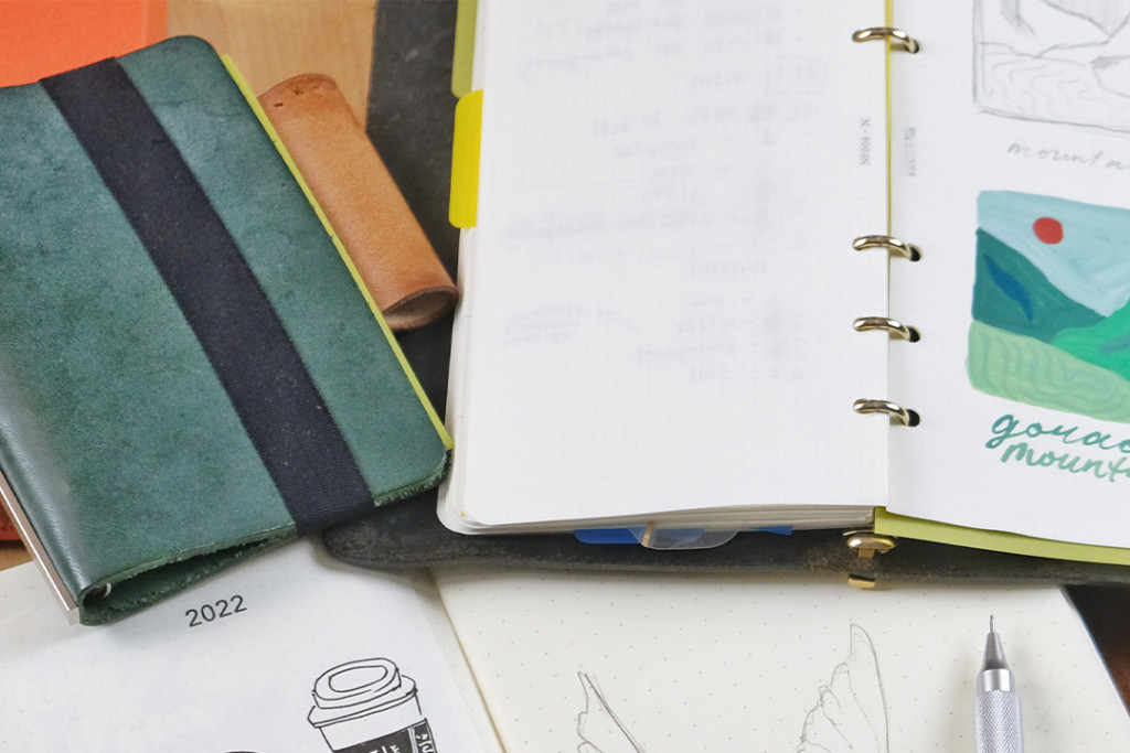 PLOTTER leather binder in Narrow Size with painting in it. PLOTTER Mini 5 Size in Green beside it.