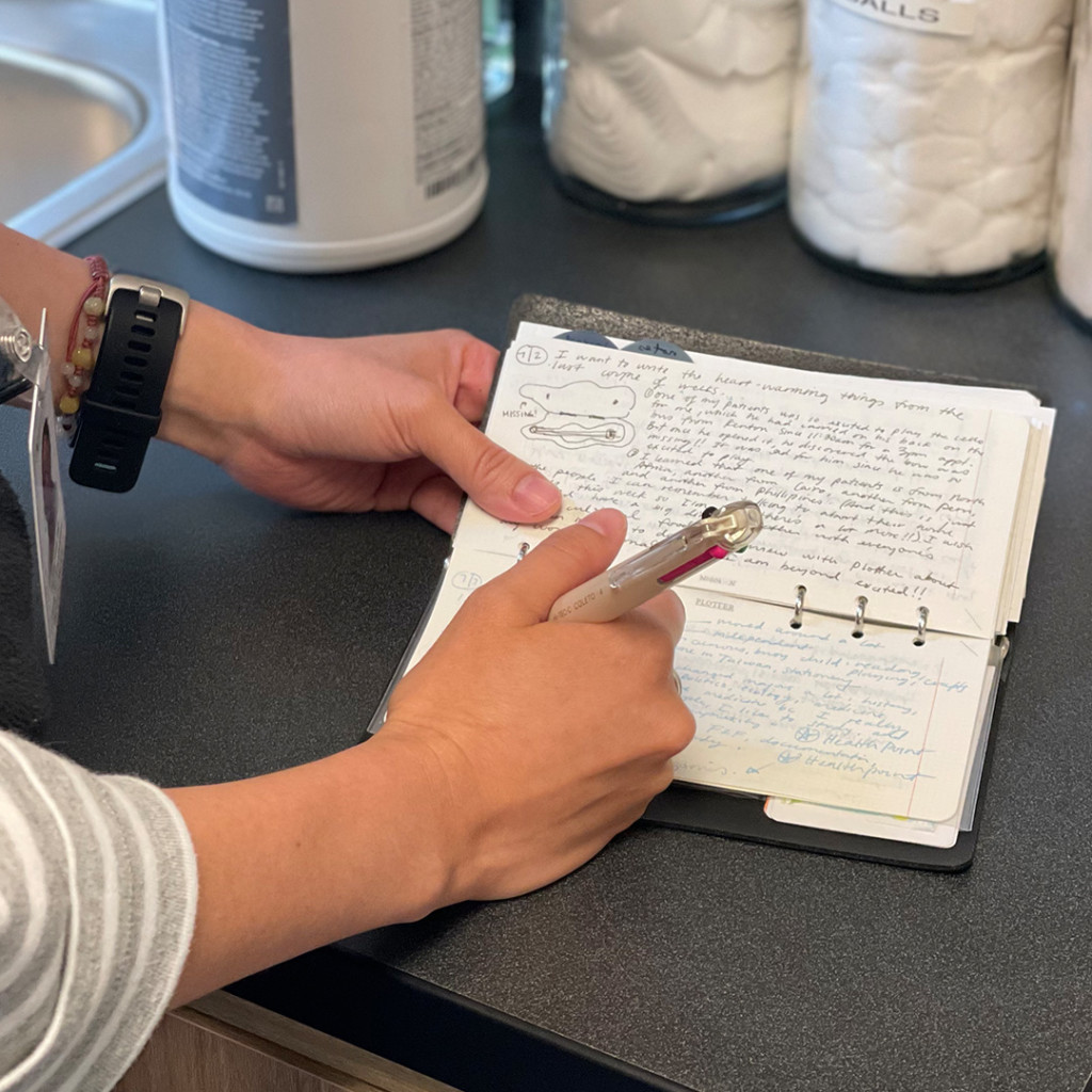 A person writing in a PLOTTER in Narrow Size filled with notes.