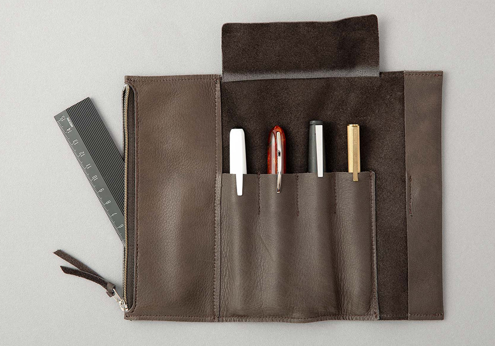 A Gray Roll Pen Case displaying four pens in each slot.