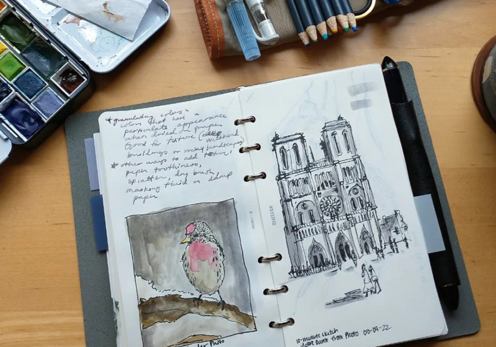 A PLOTTER in Bible Size with sketches and notes next to a leather pen roll filled with drawing tools.