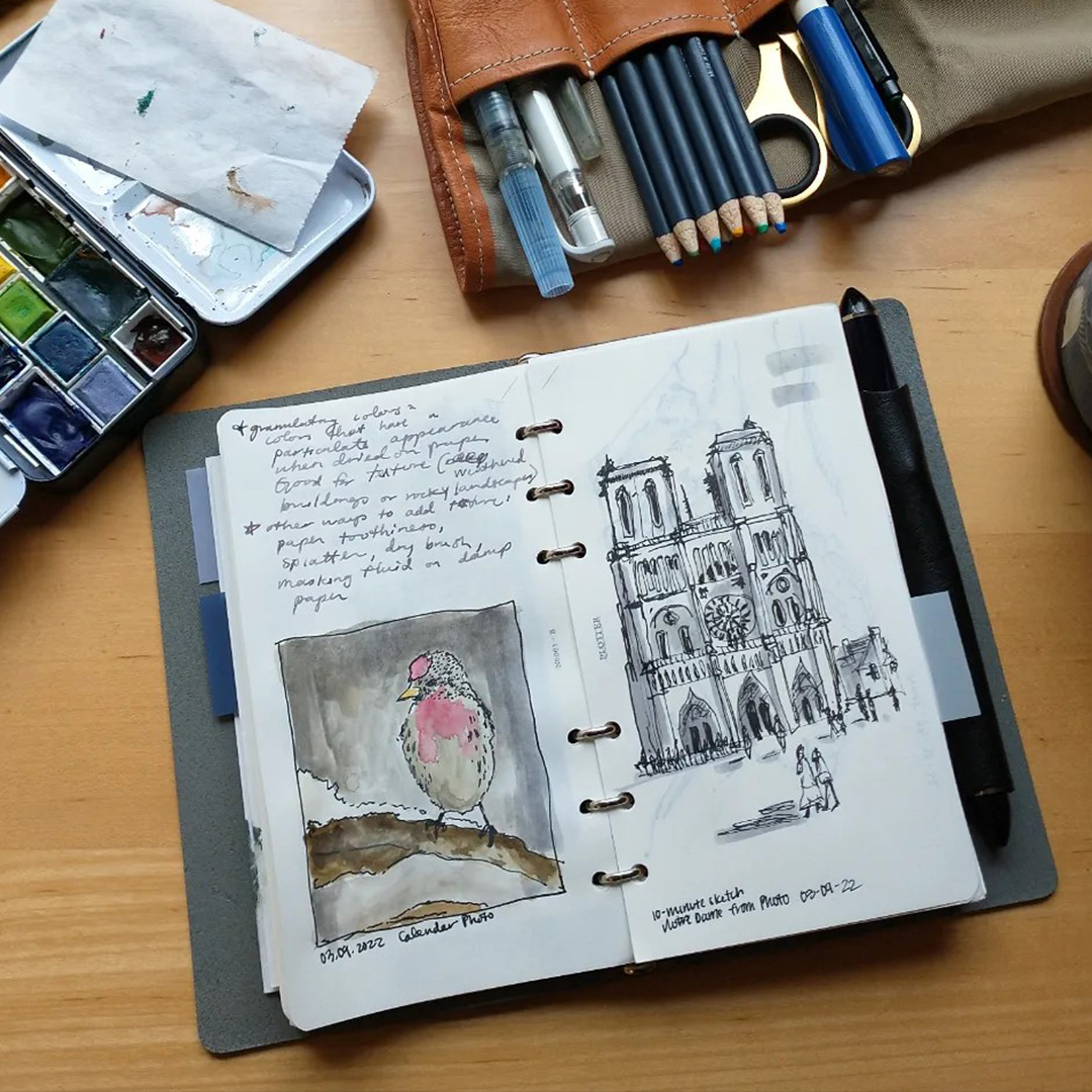 A PLOTTER in Bible Size with sketches and notes next to a leather pen roll filled with drawing tools.