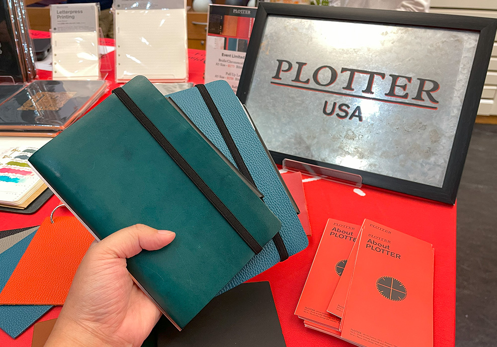 A hand holding two blue color PLOTTERs, one in Liscio blue and one in Shrink blue. 