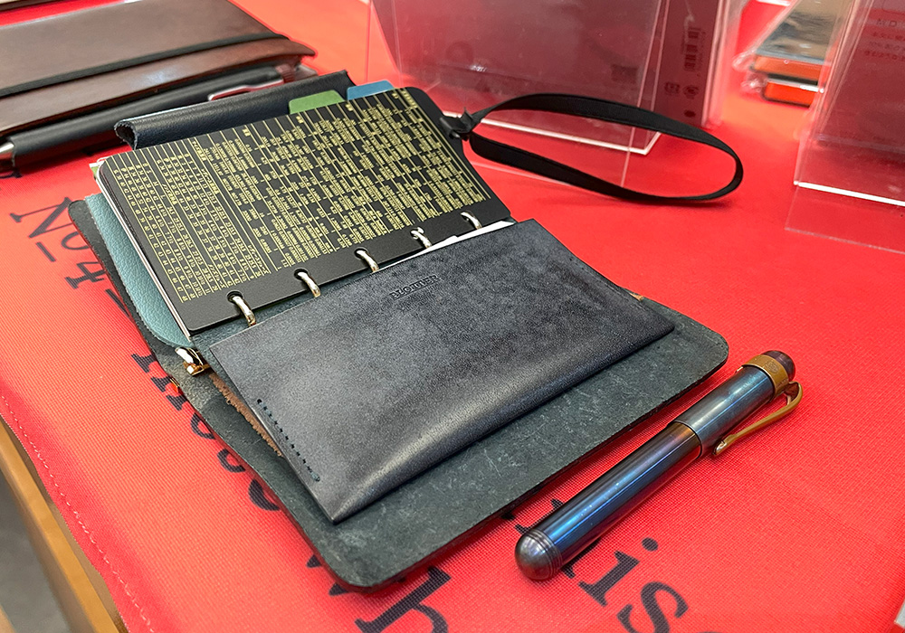 A PLOTTER leather binder in Mini 5 Size next to a pocket fountain pen.