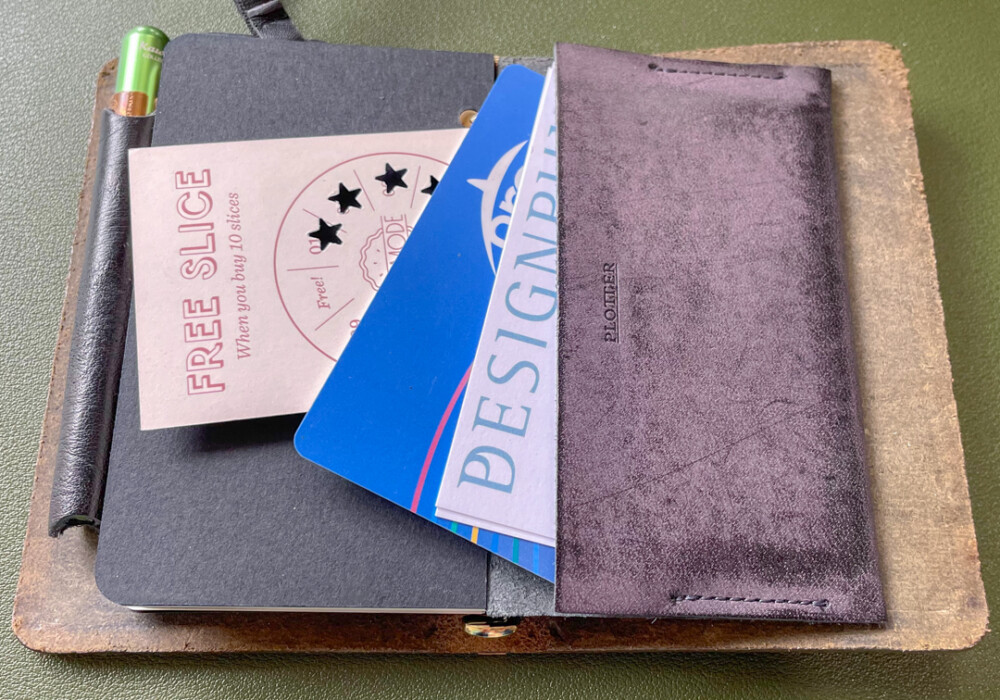A PLOTTER leather binder in Mini 5 Size holding transit cards, business cards, and punch cards.