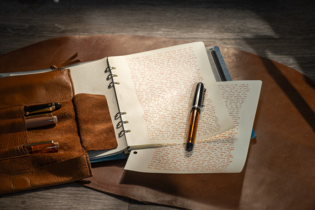 A PLOTTER Leather Binder in A5 Size with two filled pages of refill memo pad containing long form writing.