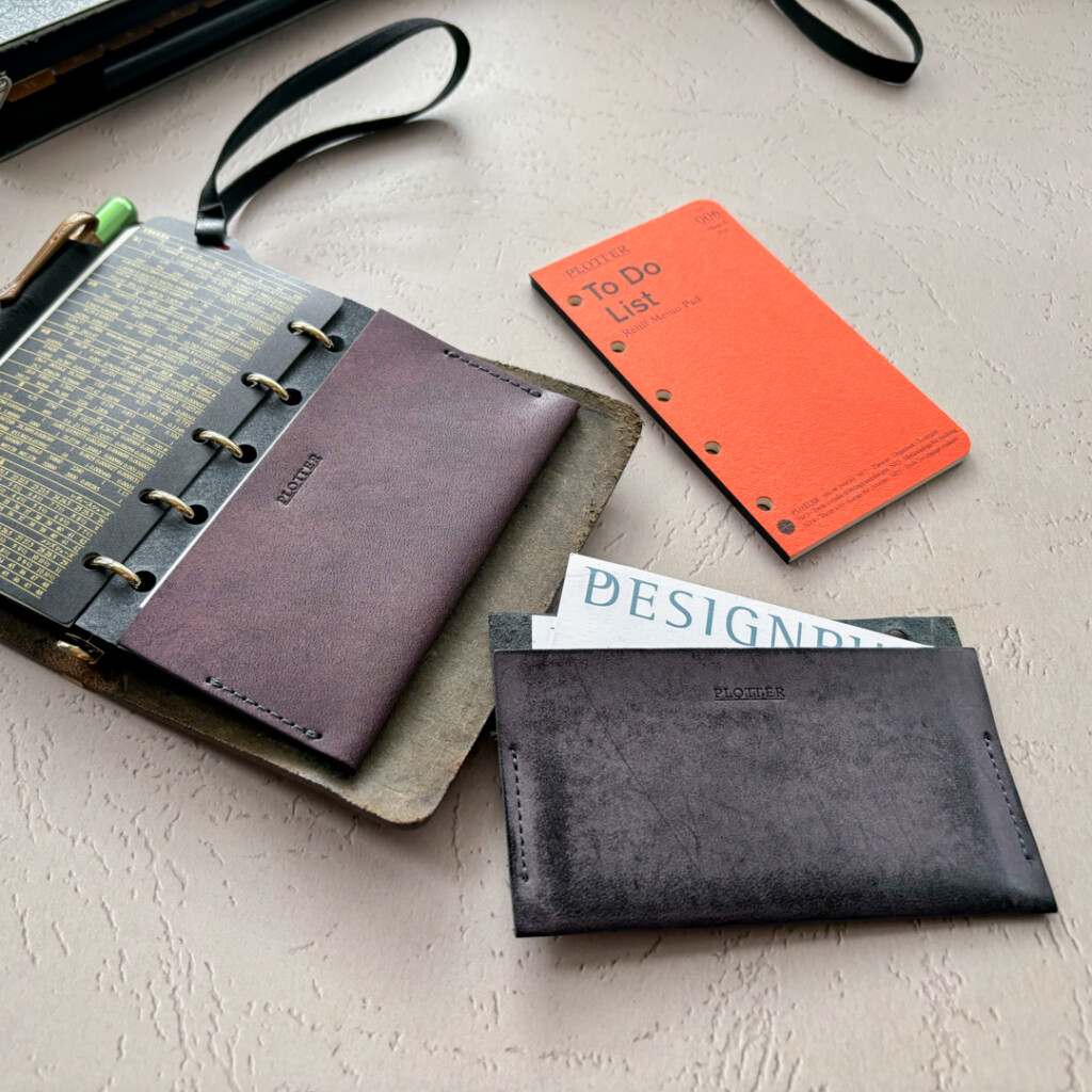 A usage example of PLOTTER Leather Card Case holding business cards. 