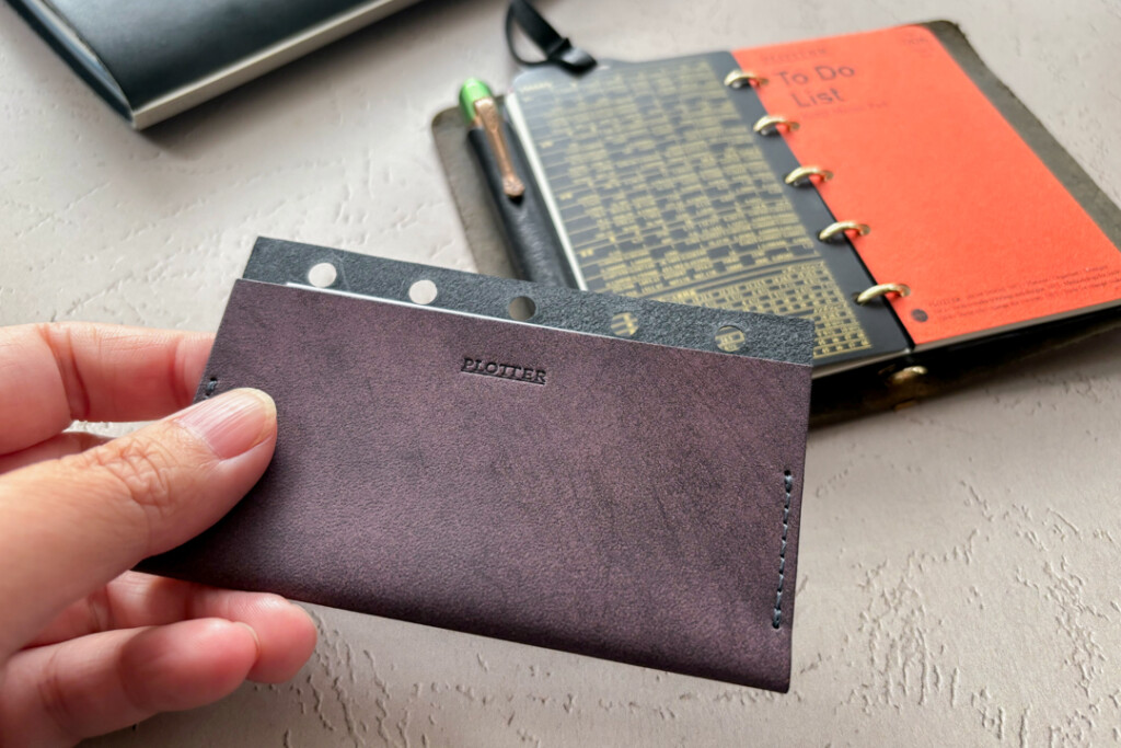 A hand holding the Limited Edition Purple Leather Card Case. 