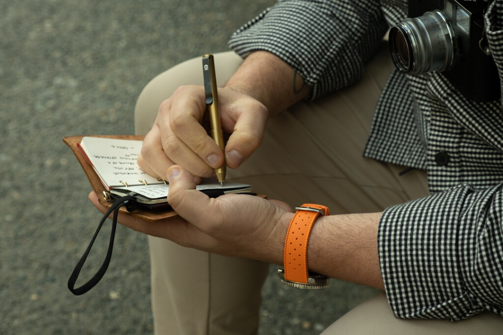 Chris Giannakos writing in his open PLOTTER Mini 5 leather binder,