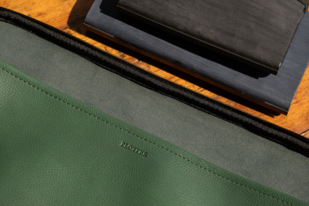 A PLOTTER A4 Mesh Zipper Case beside two PLOTTER leather binders.