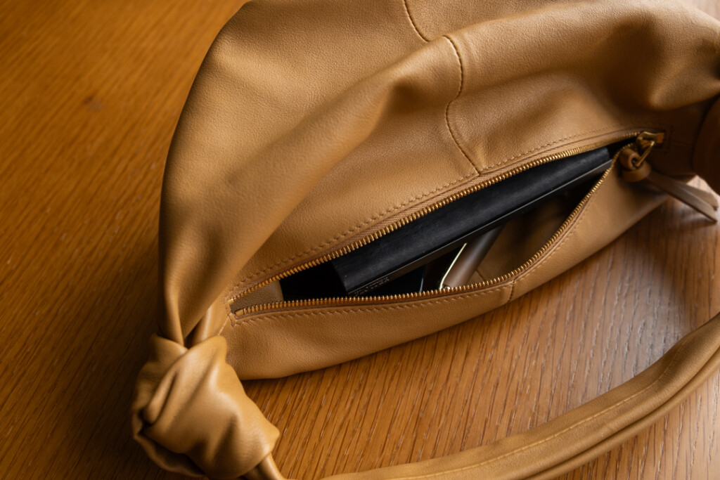 A PLOTTER Horse Hair II Mini Size Leather Binder inside a small tan purse.