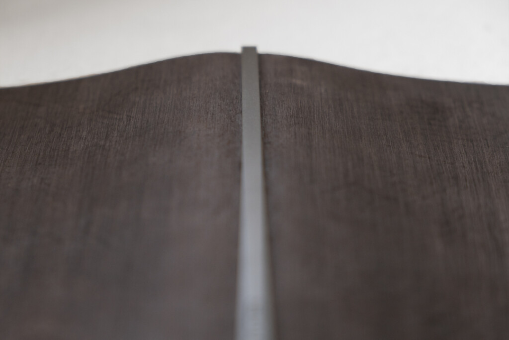 A close-up of a PLOTTER Horse Hair II Leather Binder in gray, showing the black backplate of the leather binder.