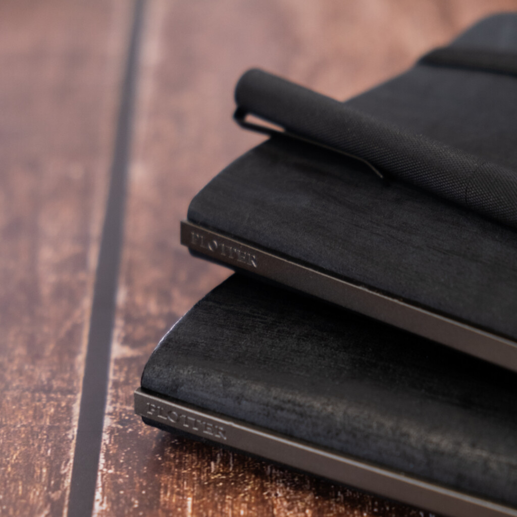 A close-up of the matte black backplates of PLOTTER Horse Hair II Leather Binders.