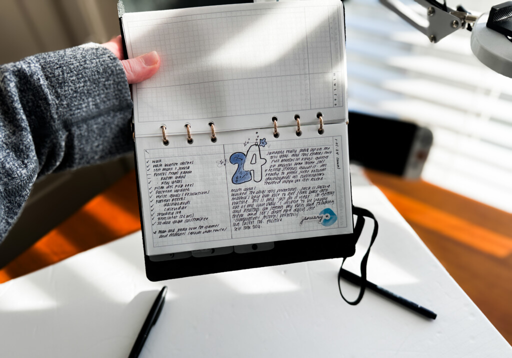 PLOTTER Bible Size Leather Binder open to a page of journaling with photos and illustrations.