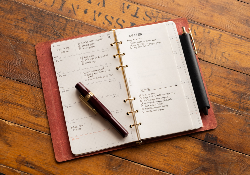 Weekly schedule notes inside a PLOTTER leather binder.