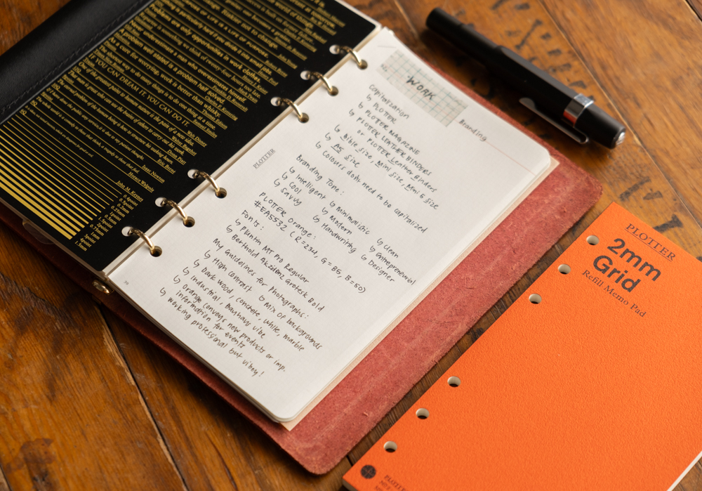 Work notes on 2mm grid paper inside a PLOTTER leather binder.
