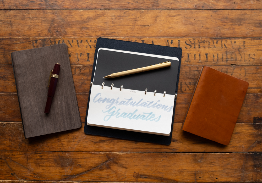 PLOTTER Leather Binder open with text saying "Congratulations Graduates".