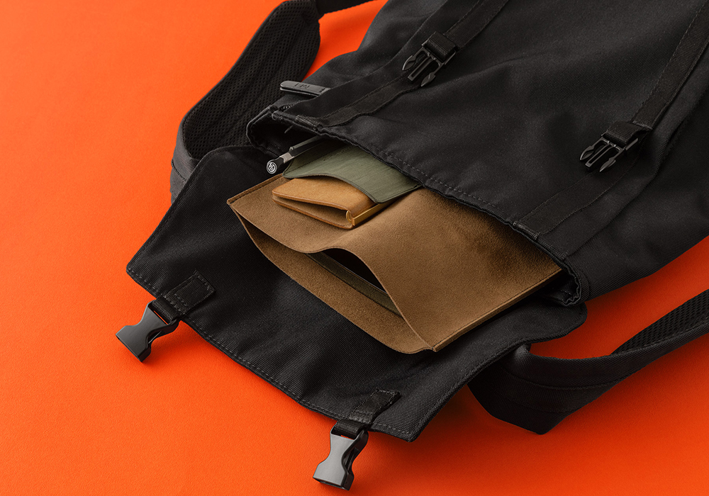 Brown x Green Leather Binder Case in a backpack.