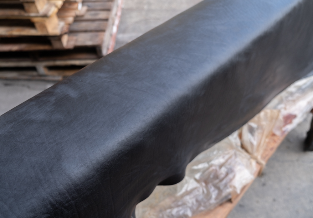 Shiranami leather drying on wooden holder after it has been indigo dyed.