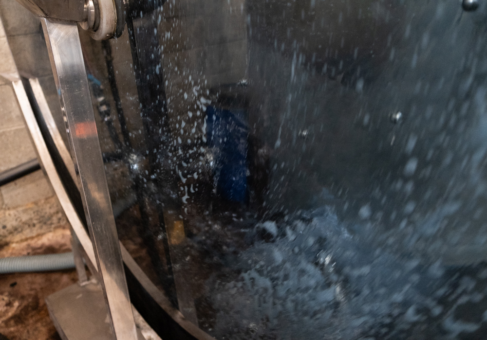 Close-up of leather in a dyeing drum that spins with indigo dye in it with warm water.