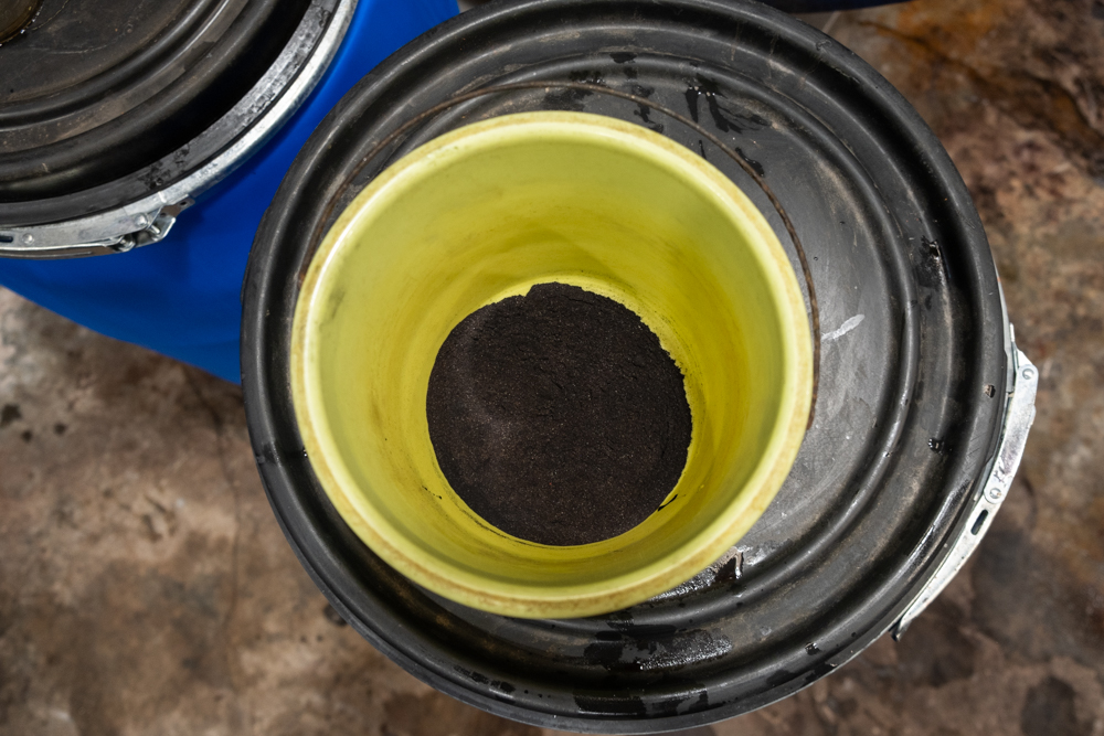 Indigo dye used for dyeing leather in a plastic pail.