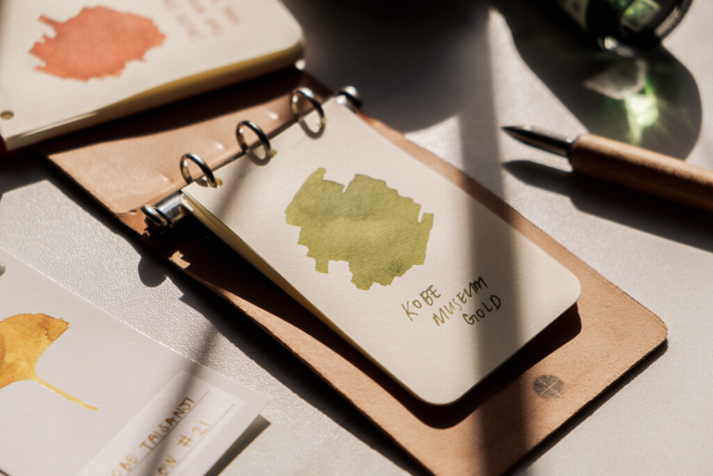 PLOTTER 3-Ring Leather Binder open to a green fountain pen ink swatch.
