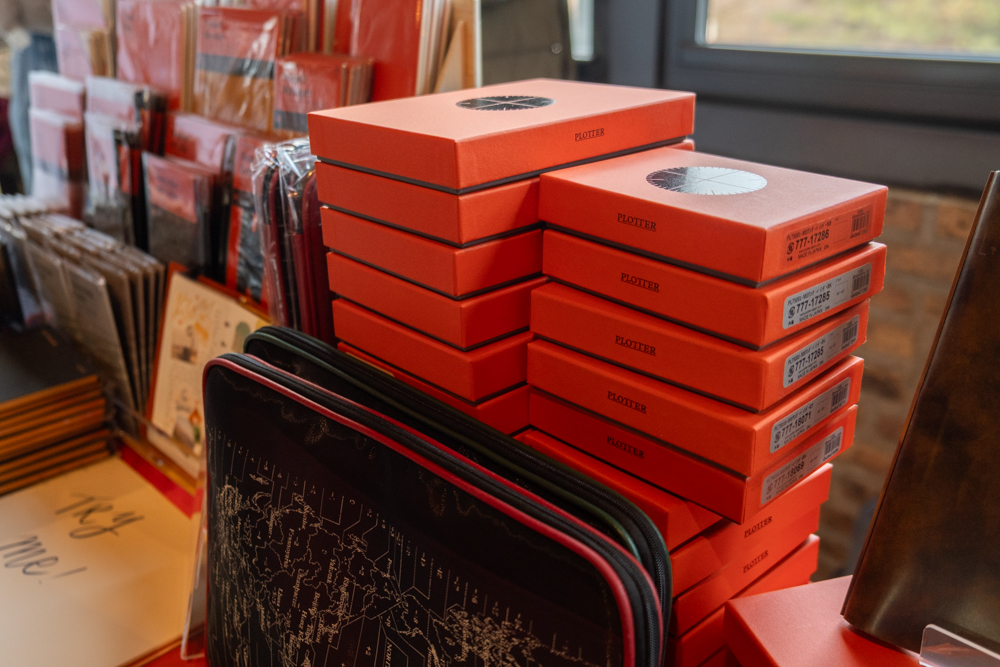 Close-up of the stack of PLOTTER boxes at the PLOTTER USA table at Chicago Stationery Fest 2025.