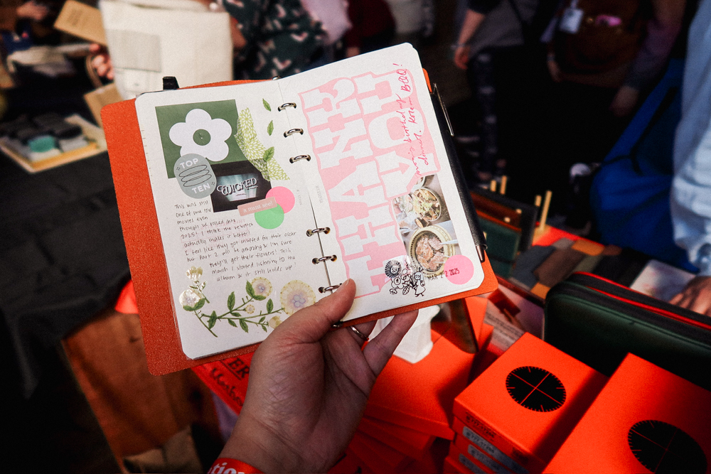 A person holding an open Bible Size PLOTTER Leather Binder to a spread of creative journaling.