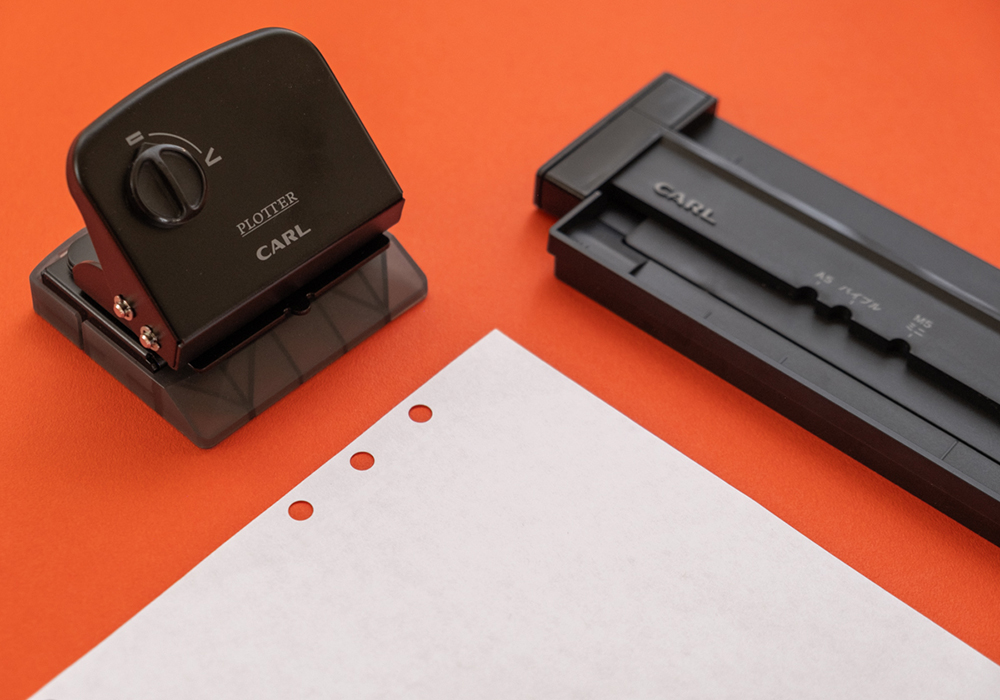 PLOTTER x CARL Refill Maker Hole Punch with a piece of white paper.