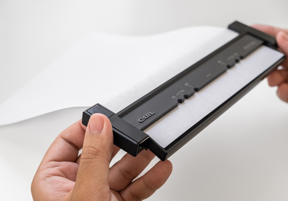 Two hands holding down the Page Holder section of the gauge.