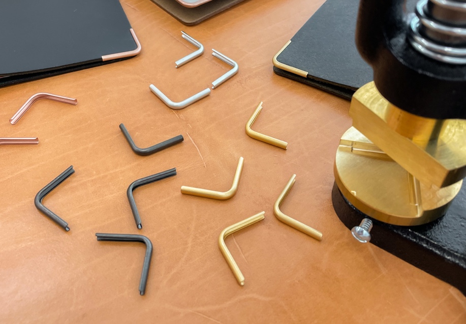 The four different colors of the PLOTTER corner hardware, which are matte black, gold, silver and rose gold.