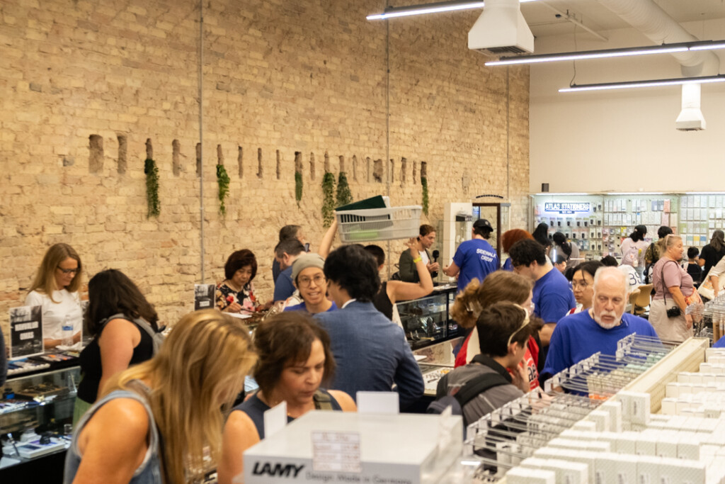 The interior of the Atlas Stationers store filled with people shopping during their sidewalk sale.
