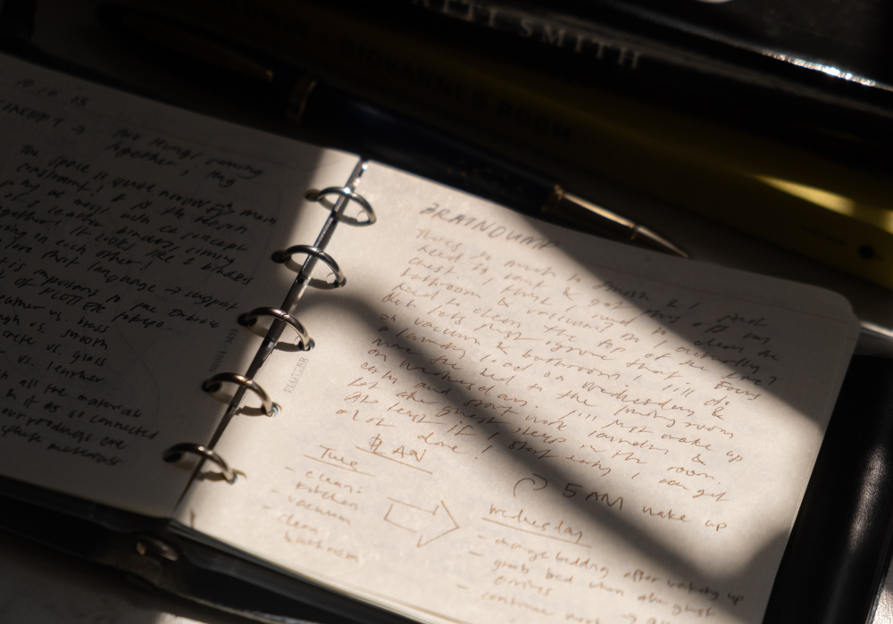 Stream of consciousness notes and journal reflections inside a PLOTTER Mini 5 Square Size Leather Binder in high contrast lighting. 