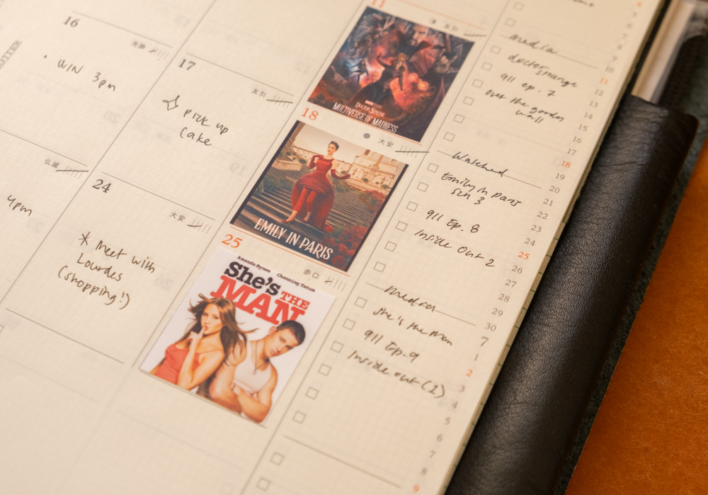 A person using the PLOTTER Diary 2026 Monthly Schedule to track what movie or show they watched on each Sunday of the month.