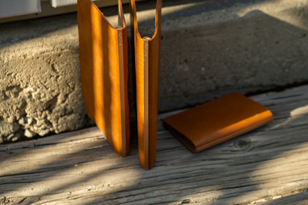 Three PLOTTER Leather Binders in Horween Predator Leather in Narrow Size, Bible Size and Mini 5 Size. All three binders are resting on a weathered wooden table.