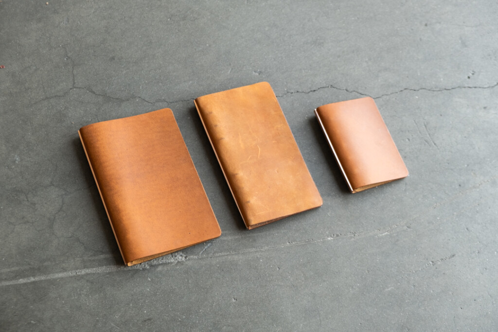 Three PLOTTER Leather Binders in Horween Predator Leather in Narrow Size, Bible Size and Mini 5 Size. All three binders are resting on concrete floor.