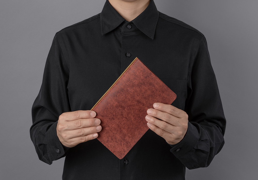Man holding a Pueblo Leather Binder in Red Brown.