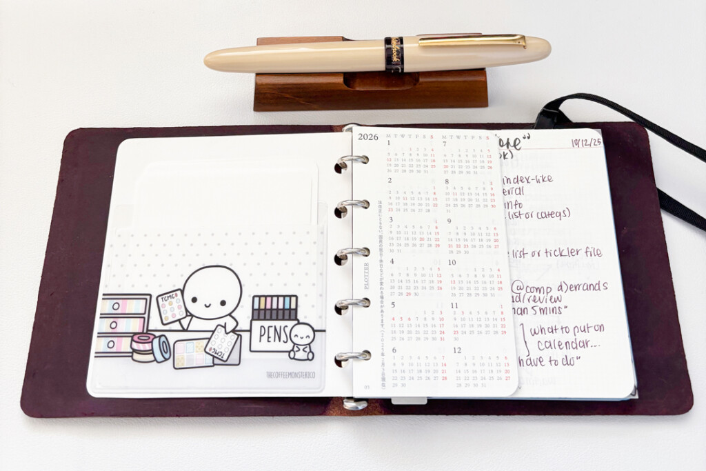 PLOTTER Leather Binder in Mini 5 Square Size open to two a page filled with stickers and a page full of calendars.