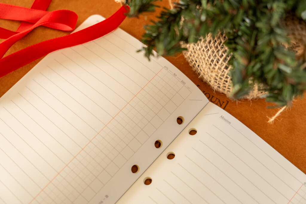 A close up of a PLOTTER Refill Memo Pad To-Do List near holiday decoration on top of a leather placemat.