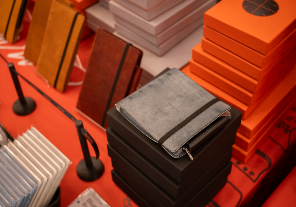 A close-up of the PLOTTER USA table showcasing the event-limited and PLOTTER USA-exclusive leather binders.