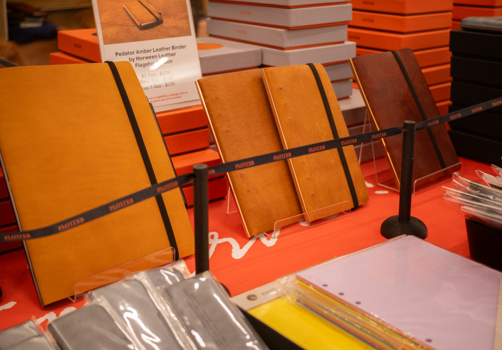 A close-up of the PLOTTER USA table showcasing the event-limited and PLOTTER USA-exclusive leather binders.