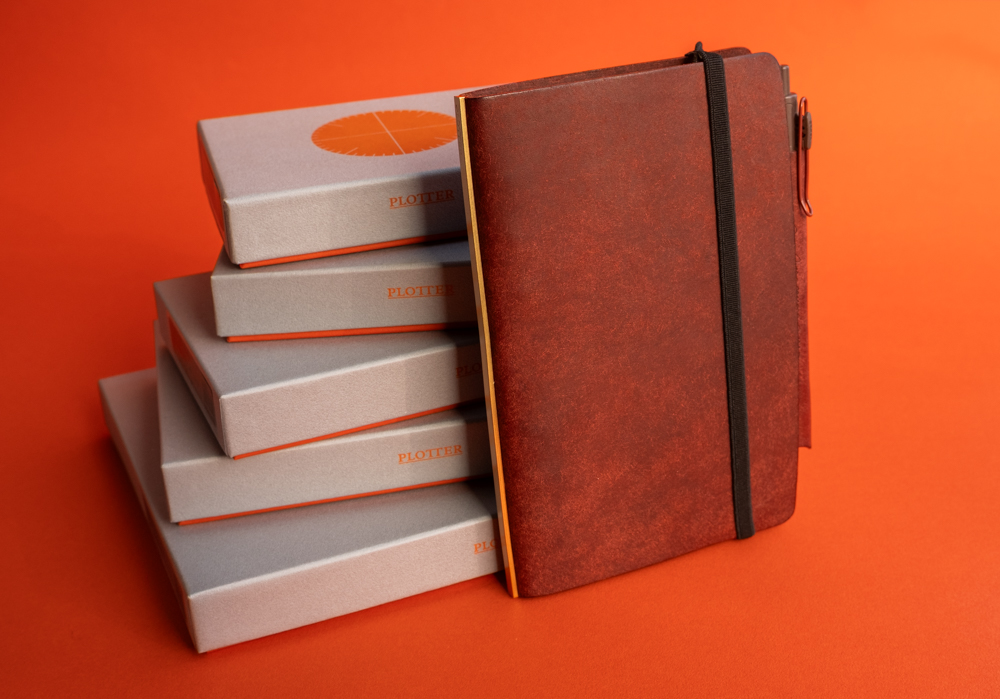 A Pueblo Red Brown leather binder leaning against five boxes for the Limited BOX sets.