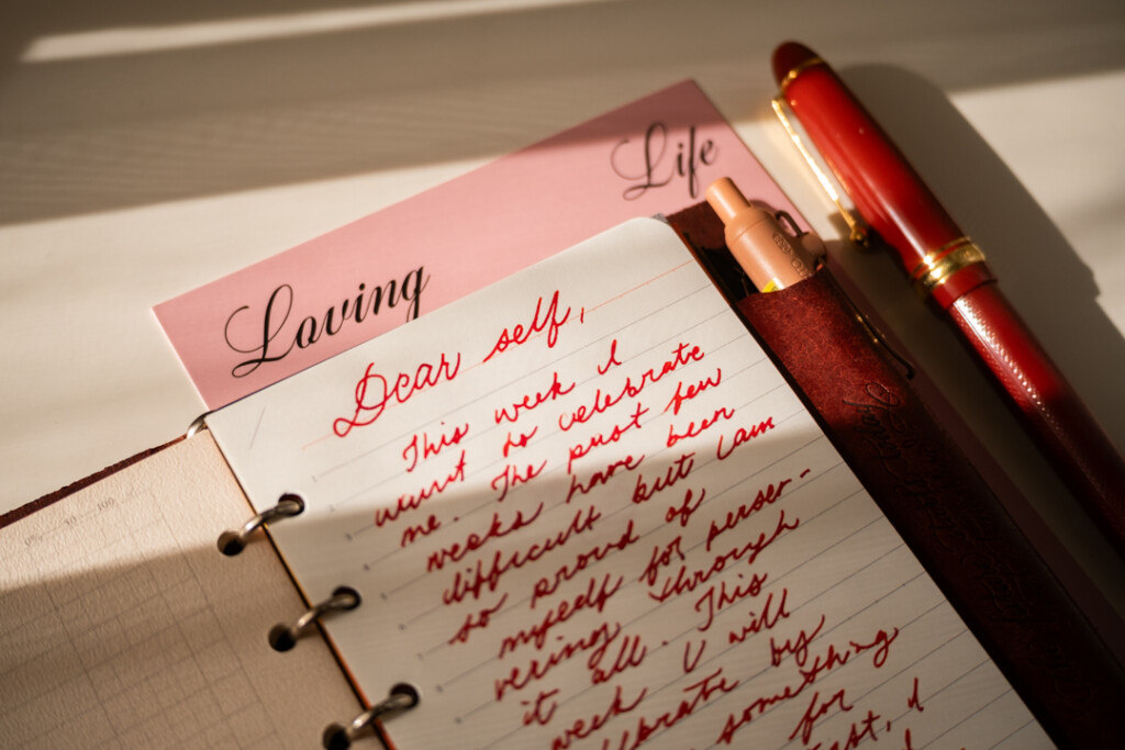 A close-up of a PLOTTER Leather Binder open to a self-written letter, which is about self-care.
