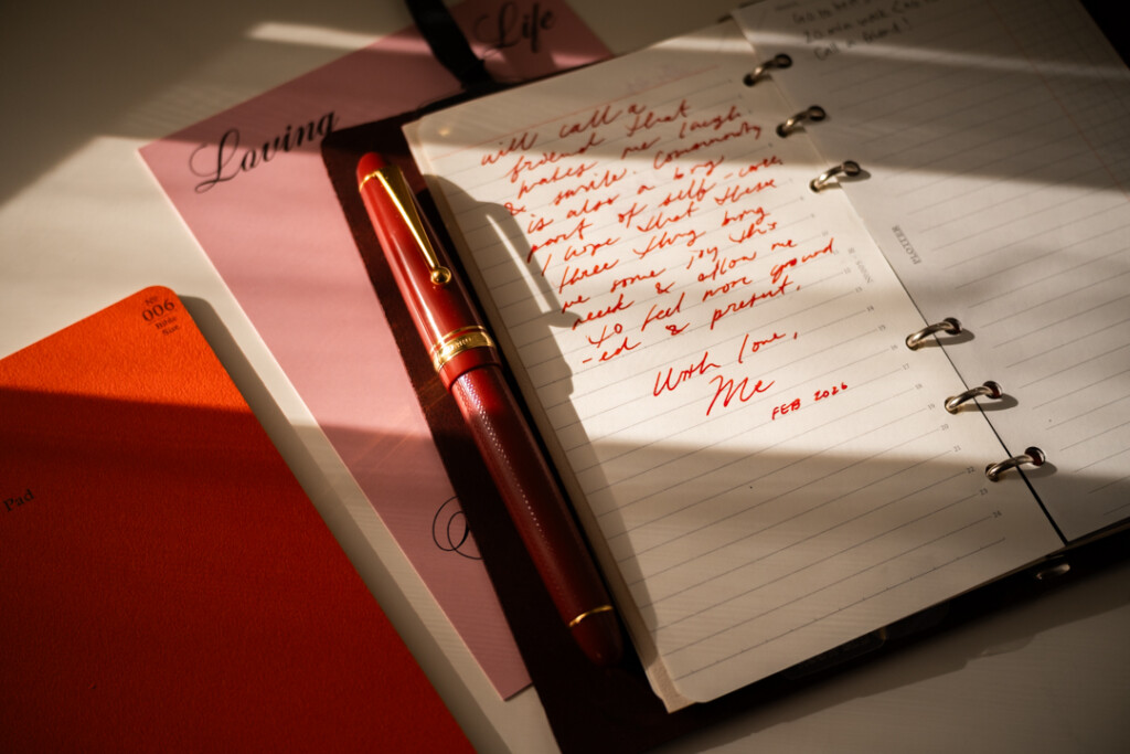 A PLOTTER Leather Binder open to a self-written letter, which is about self-care, beside PLOTTER Refill Memo Pads and fountain pens.